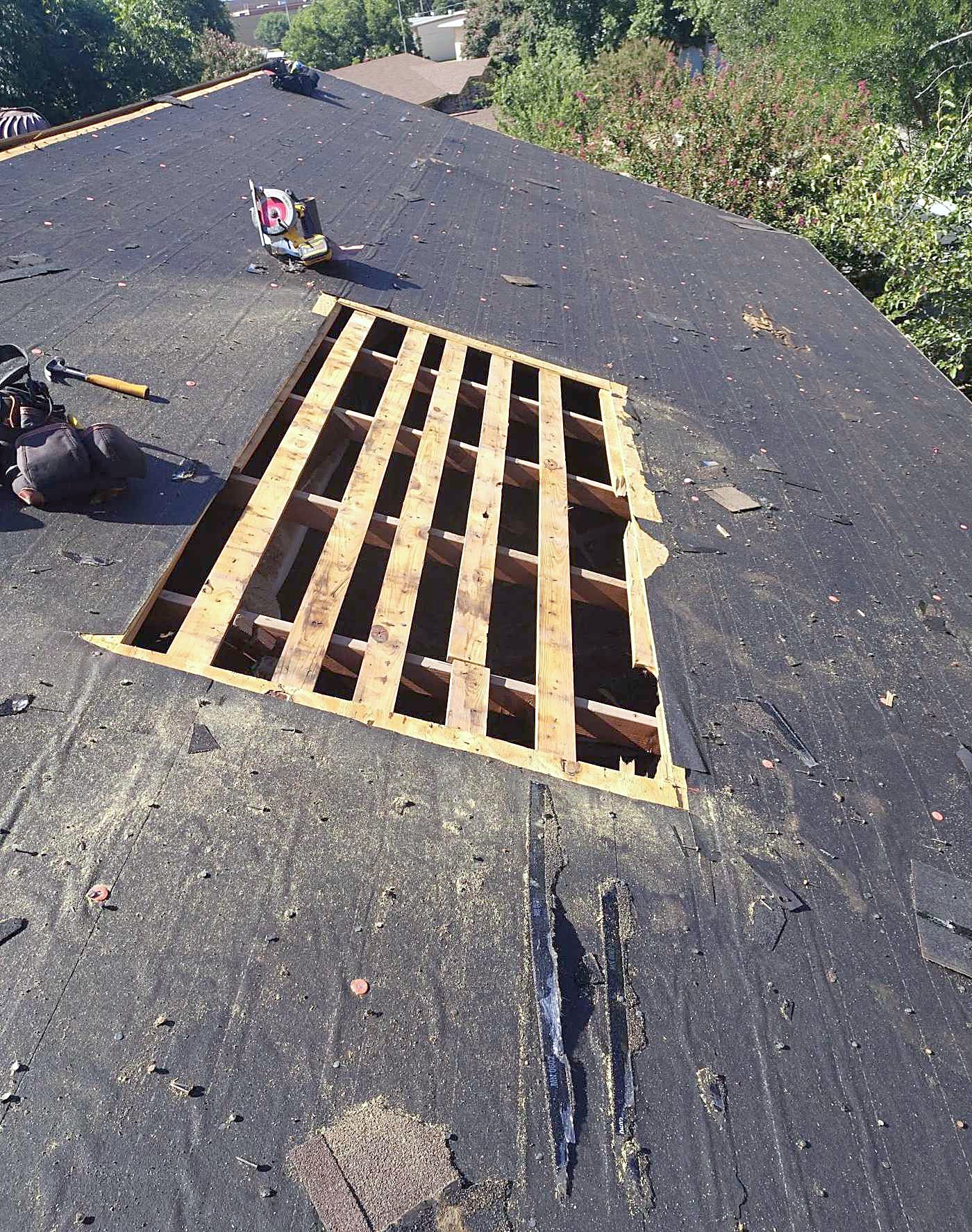 A roof stripped back to bare decking and rafters after a tear-off